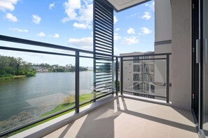 Un balcone con vista su un lago e edifici sullo sfondo.
