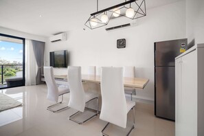 Una cucina moderna con zona pranzo, frigorifero in acciaio inox e un'ampia finestra con vista panoramica.