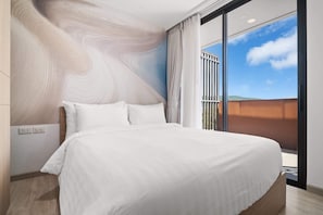 A modern hotel room with a large bed, a view of the outdoors, and a unique wall design.