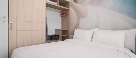 Una habitación de hotel con una cama grande, un armario con varios estantes y una pared con un diseño abstracto ondulante.