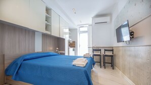 Una habitación de hotel con cama, escritorio y televisión.