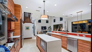 Une cuisine moderne avec des meubles en bois, des appareils électroménagers en acier inoxydable et un îlot central.