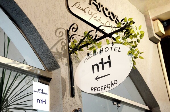 Une enseigne d’hôtel indiquant « METRO HOTEL » et « RECEPCAO » (réception).