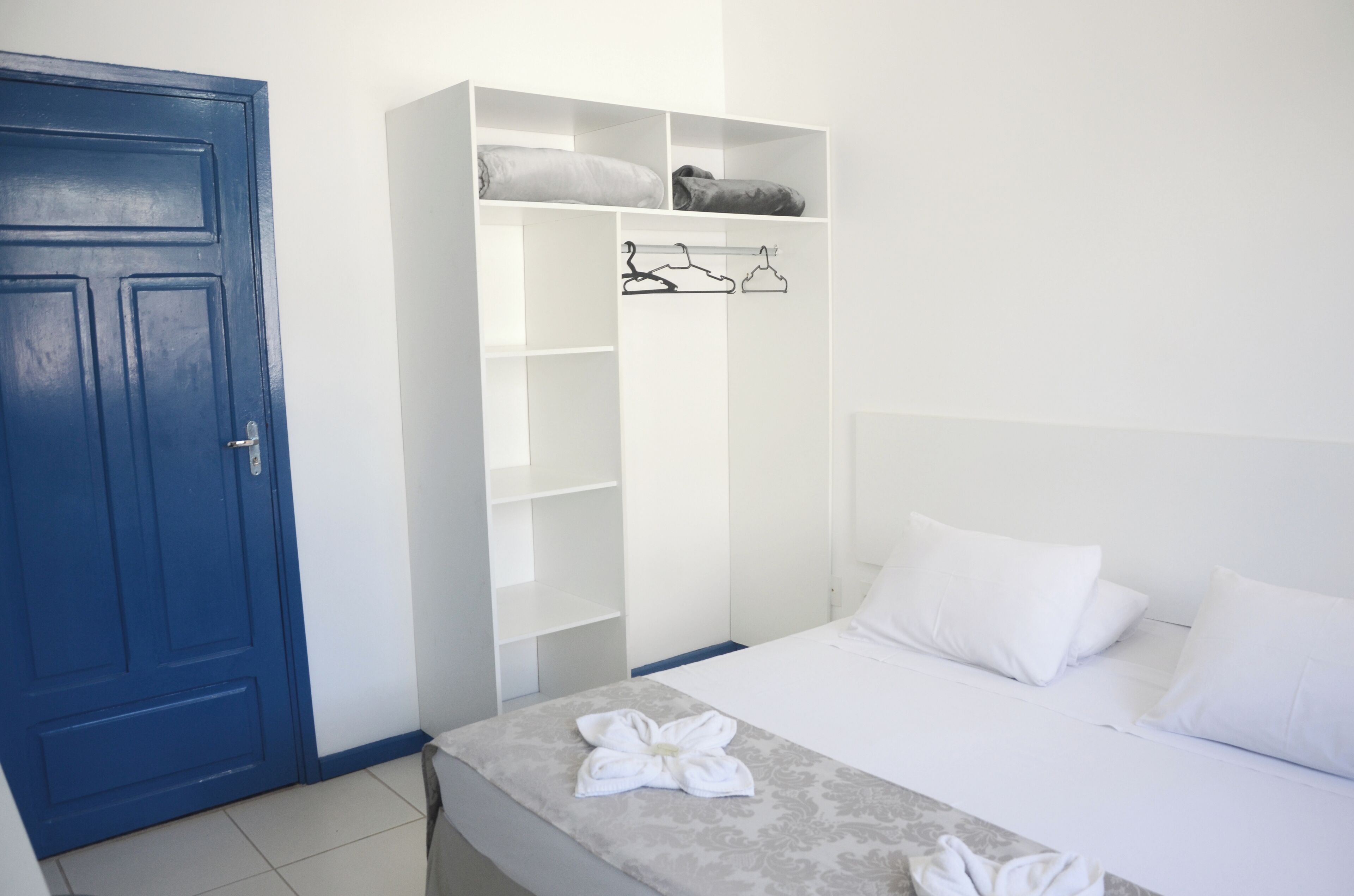 A bedroom with a bed, a wardrobe, and a blue door.