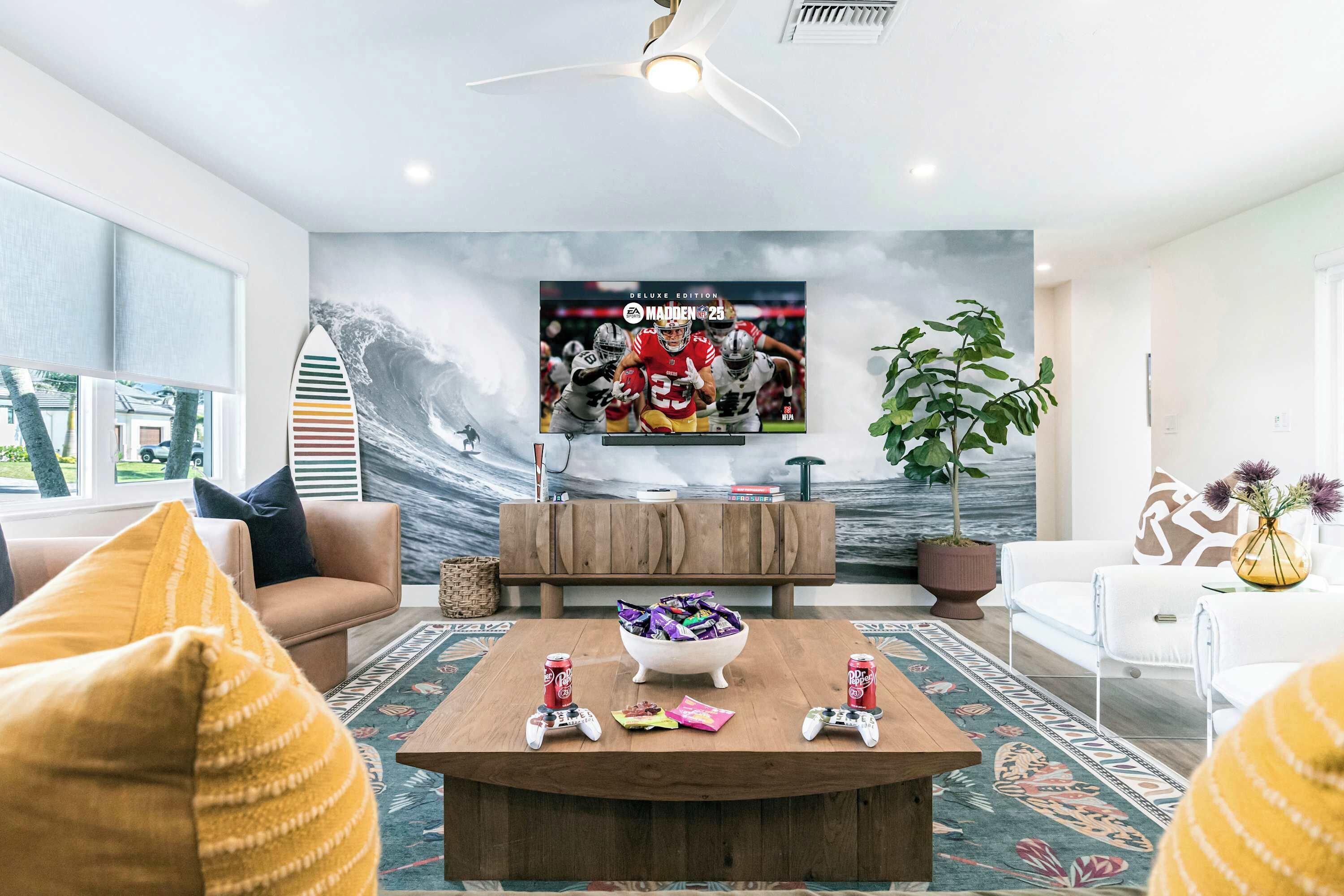 A modern living room with a large TV displaying a football game, a wooden coffee table with snacks and drinks, and comfortable seating.