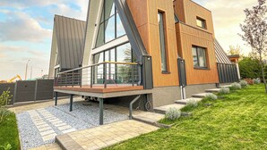 Un bâtiment moderne doté d’un toit en pente, de grandes fenêtres et d’une façade en bois.