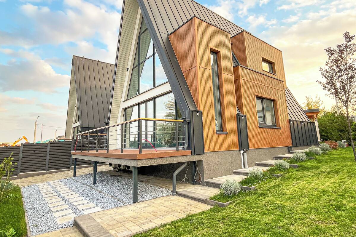 A modern building with a sloped roof, large windows, and a wooden facade.