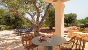 An outdoor seating area with a table, chairs, and a view of trees and landscape. - TD ApulianRetreat Sea view trullo w/heated pool (Costa Merlata)