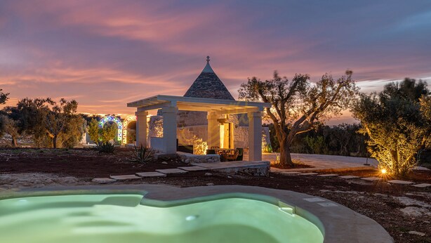 A gazebo with a stone roof, surrounded by trees and a swimming pool. - TD ApulianRetreat Sea view trullo w/heated pool (Costa Merlata)