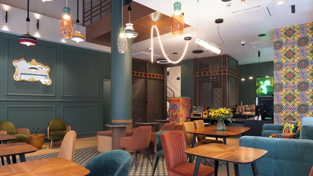A modern restaurant interior with wooden tables and chairs, decorative lighting, and patterned walls. - ATHENS RETRO (Athens)