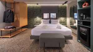 A modern hotel room with a large bed, a bench, a wardrobe, and a minibar. - ATHENS RETRO (Athens)