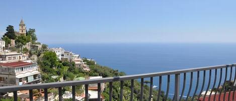 A coastal town with buildings on a hillside overlooking the sea.