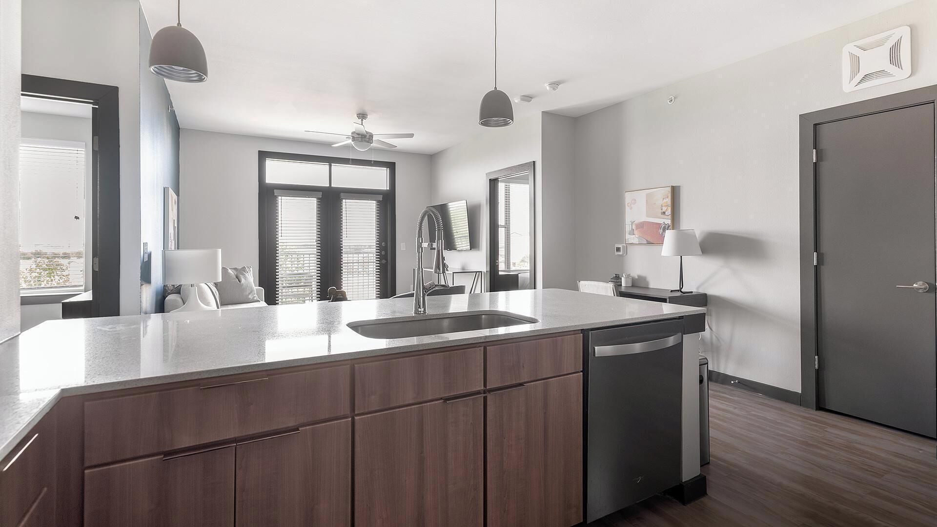 Une cuisine moderne dotée d’un grand îlot central, d’appareils électroménagers intégrés et offrant une vue sur la ville.