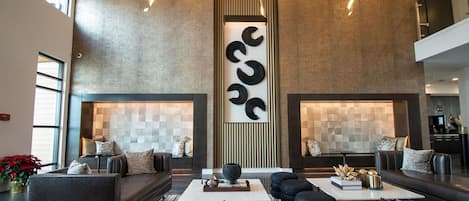 Una sala de estar moderna con sofás, una mesa de centro y decoración en la pared.