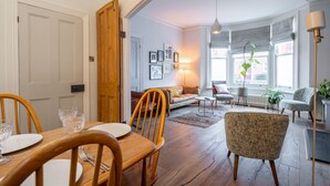 Un salon chaleureux avec une table à manger en bois, des chaises et un canapé.