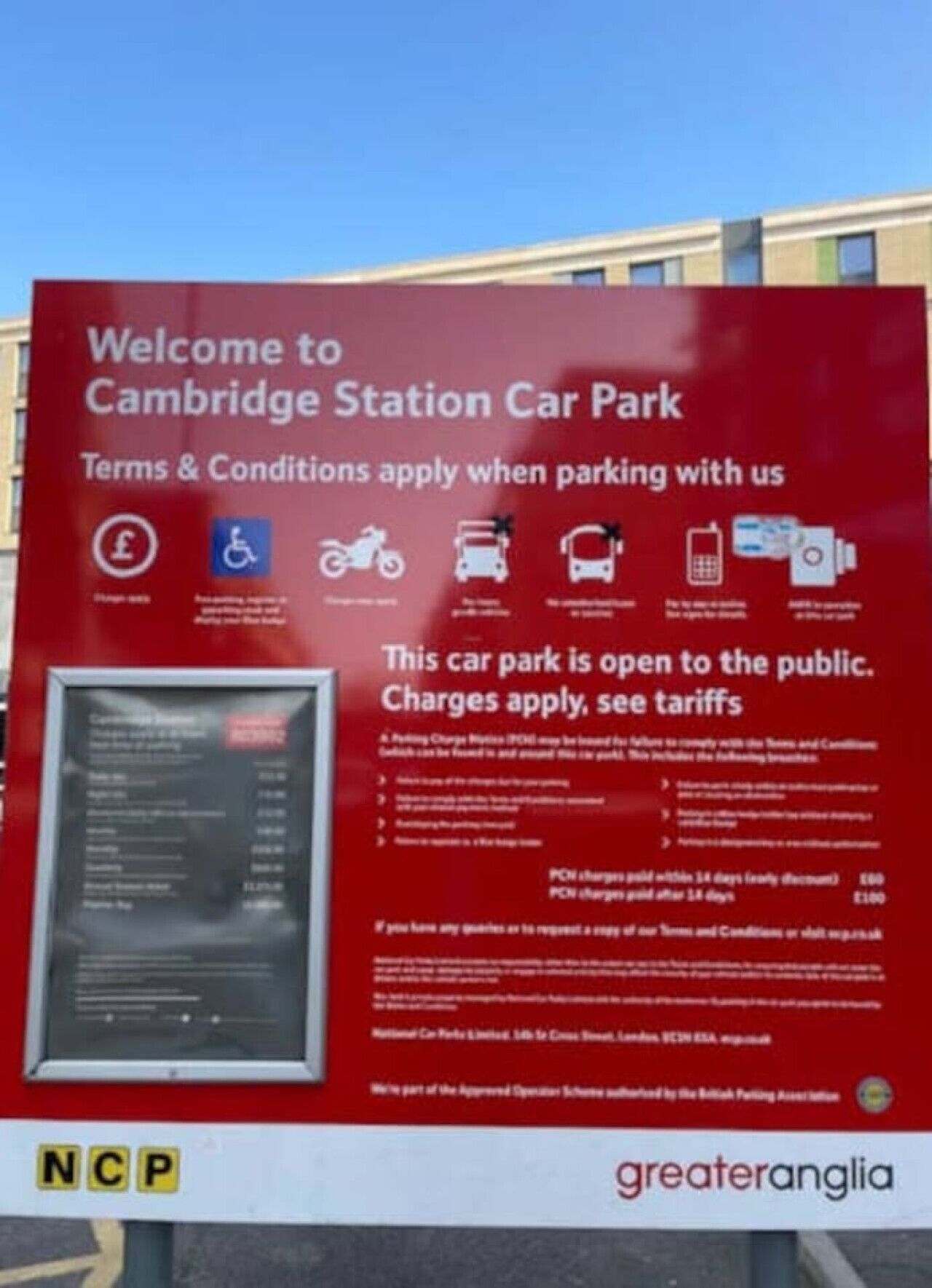 Een bord voor de parkeerplaats Cambridge Station met voorwaarden, parkeerregels en een overzicht van tarieven.
