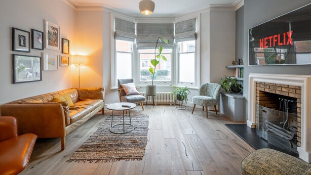 Un salon avec un canapé en cuir, une table basse, une cheminée et une bibliothèque.