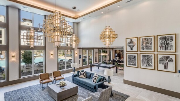 A spacious living area with a pool view, modern furniture, and art on the walls. - Landing | Modern 1BD, Game Room, Gym (Allen)