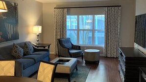 Un salon moderne comprenant un canapé, des fauteuils, une table basse, une table à manger et un téléviseur.