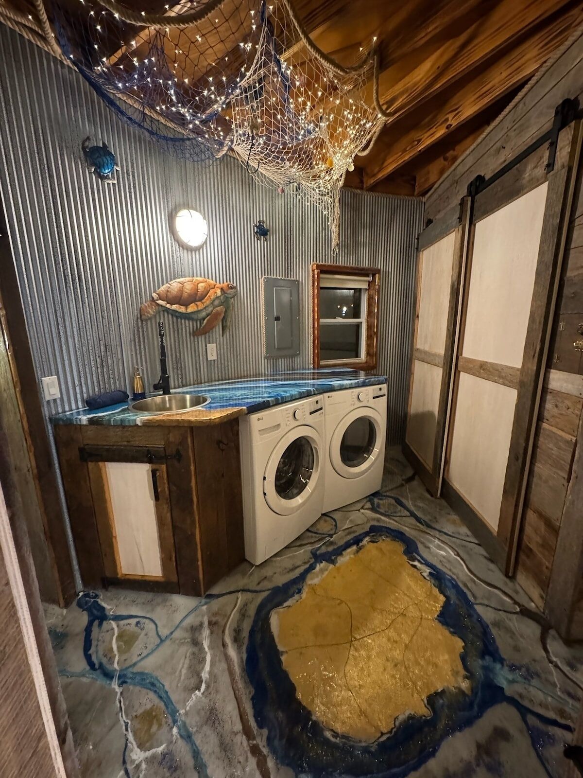 A compact, rustic bathroom with a washing machine, a sink, and a decorative ceiling light.