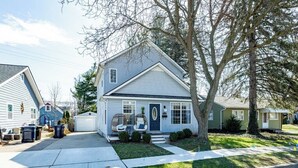 A two-story house with a front porch, a garage, and a well-maintained lawn.