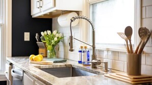 A kitchen with a modern faucet, a sink, and a window above the counter.
