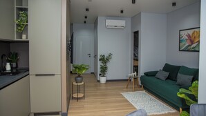 Eine moderne Wohnung mit Küche, einem grünen Sofa und einem Essbereich.