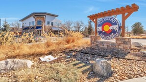 A Colorado Tap House sign with a modern building in the background. - Charming 3-bedroom, 4 Bath Townhome in Arvada, CO (Arvada)