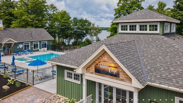 A building with a pool, outdoor seating, and a sign reading "Water's Edge". - The Snowberry - 67 Butternut (Prince Edward)