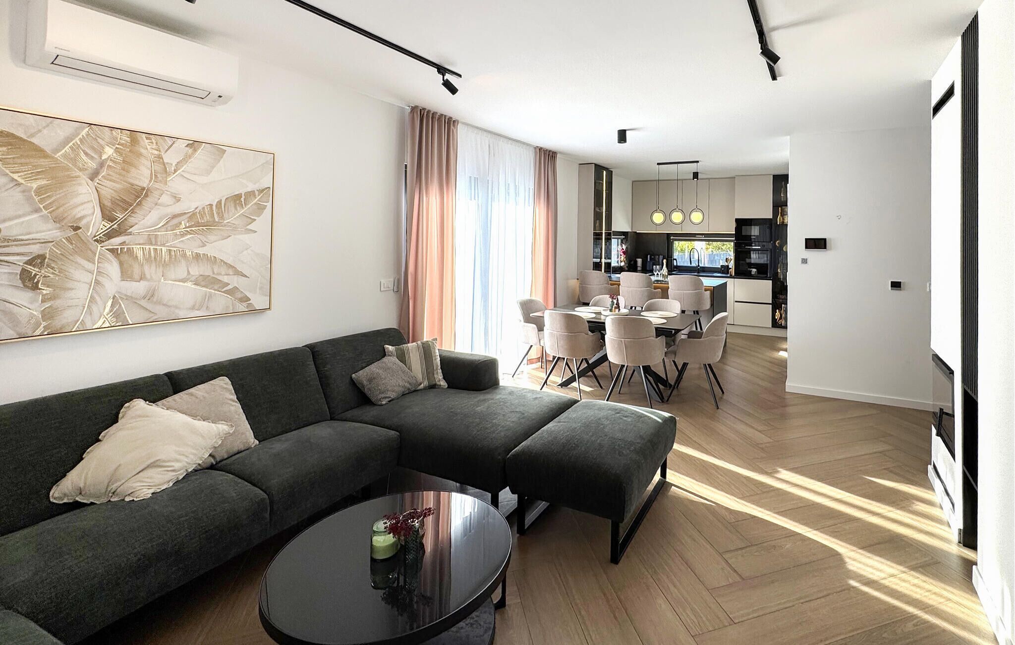 Ein modernes Wohnzimmer mit einem Ecksofa, einem Couchtisch und einem Essbereich mit Stühlen und einem Tisch.