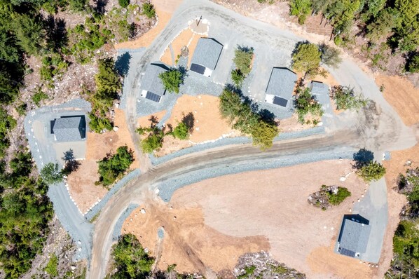 An aerial view of a residential area with multiple houses, roads, and a river.