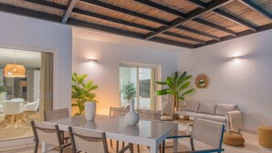 Un'area pranzo moderna con un tavolo in vetro, sedie e piante in vaso.