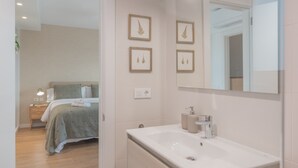 Un baño moderno con un lavamanos grande, un espejo y una obra de arte en el muro.