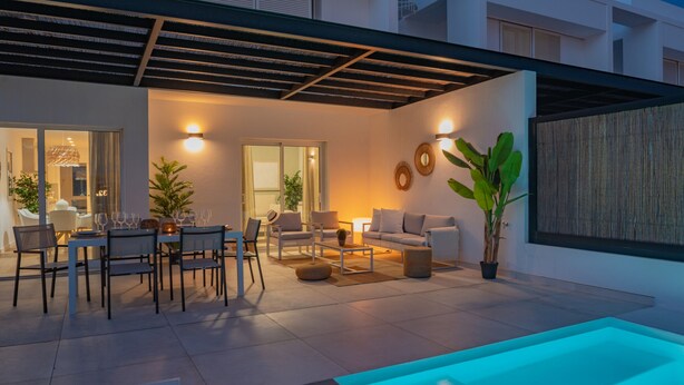 A modern outdoor living area with a pool, seating, and a dining setup. - Villa Serena Luca (Playa Blanca)