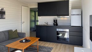 A compact kitchen with dark cabinets, a built-in oven, and a coffee maker. - 2 bedroom lovely home in ørsta (Ørsta)