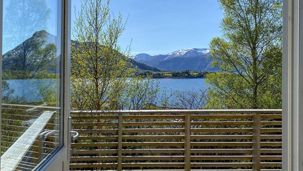 A balcony with a view of a lake and mountains.