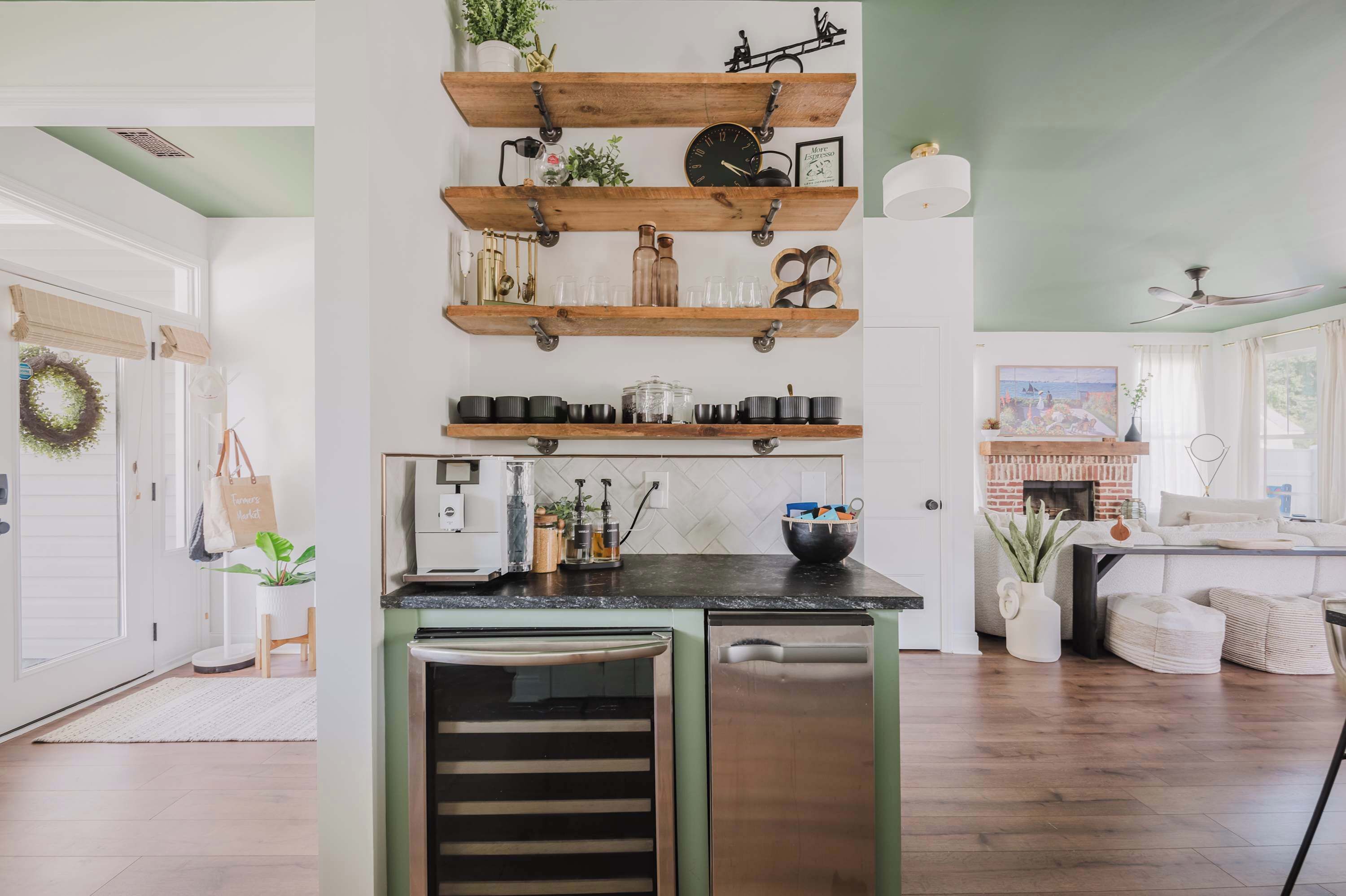 A kitchen with wooden shelves, a refrigerator, and a dining area with a sofa.
