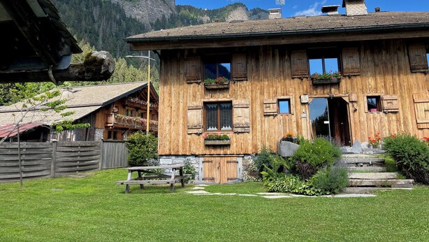A wooden chalet with a stone foundation, a wooden balcony with flower boxes, and a stone staircase leading to the entrance. - Appartment 4 persons in Morzine (Morzine)