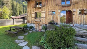 A rustic wooden chalet with a stone pathway leading to a wooden bench. - Appartment 4 persons in Morzine (Morzine)