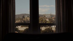 Blick durch ein Fenster auf eine hügelige Landschaft, einschließlich einer markanten Höhenstruktur.
