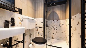 Une salle de bain moderne équipée de toilettes, d’un lavabo et d’une zone douche.