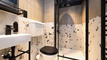 A modern bathroom with a toilet, sink, and shower area.