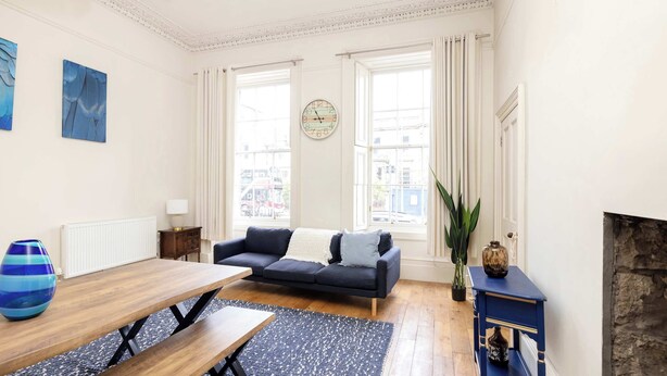 A living room with a sofa, coffee table, and fireplace.