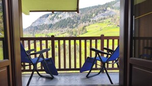 A balcony with two blue chairs and a wooden railing, overlooking a mountainous landscape. - Apartment with pool at the foot of the slopes (Flumet)