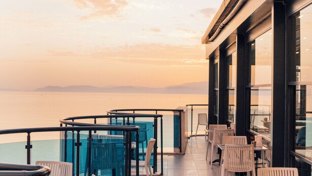 A rooftop terrace with outdoor seating and a view of the sea. - Signature Blue Resort (Kuşadası)