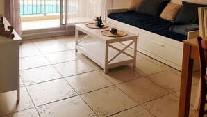 Un saló amb un sofà, una taula de centre i vista a una piscina a través d'una porta corredissa.