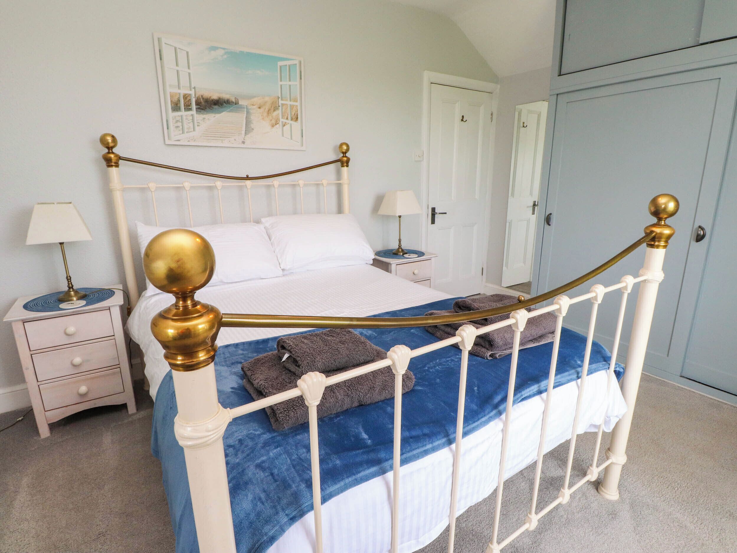 Un dormitorio ordenado con cama, mesitas de noche y armario.