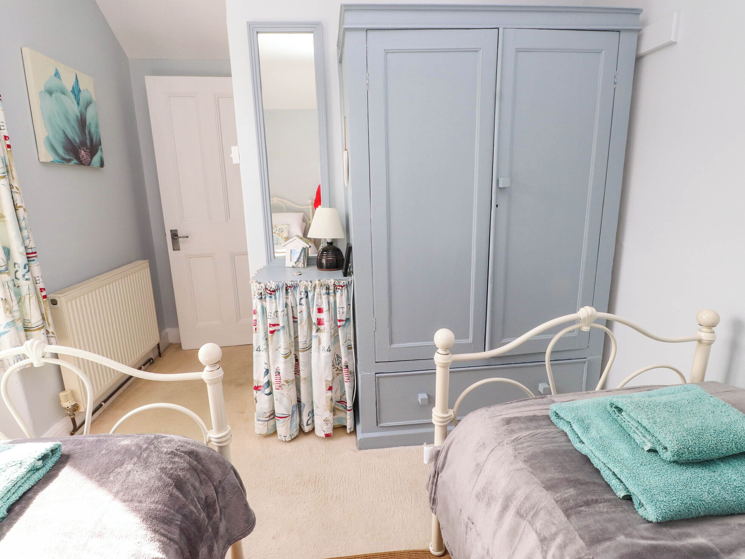 Une chambre à coucher avec un lit, une table de chevet, un miroir et une armoire.