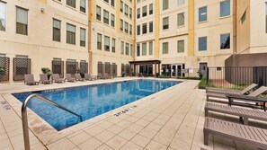 A swimming pool with lounge chairs and a covered seating area in a courtyard of a multi-story building. - Elegant 2BD | DT Dallas | Sleeps 16 | ValetParking (Dallas)