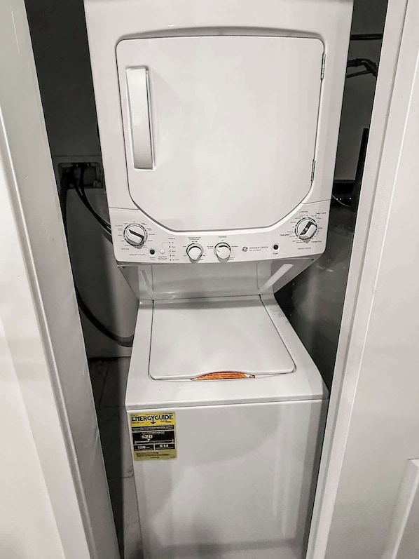 A front view of a washer and dryer unit with control knobs, a start button, and a label indicating energy efficiency.